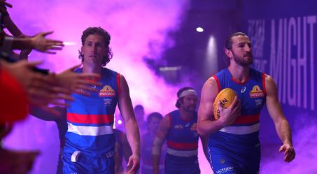 A Western Bulldogs player carries the match ball through the race